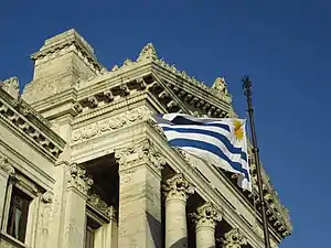 Uruguayan flag waving in front of the palace