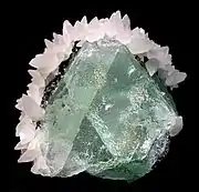 Green fluorite framed by white calcite, Naica Mine, mined in the 1980s. Size: 5.5 cm × 5.1 cm × 4.4 cm (2+1⁄4 in × 2 in × 1+3⁄4 in).