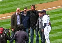 Randy Johnson in a black suit. To his left is Jay Buhner and Dan Wilson. To his right is Edgar Martínez and Ken Griffey Jr.