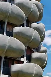The curved balconies in front of each apartment's windows