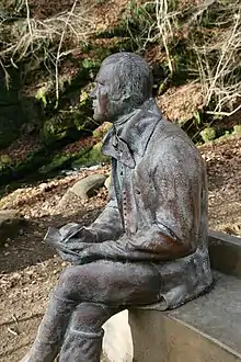A statue of Robert Burns, composing his poem 'The Birks of Aberfeldy'.