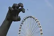 The statue's hand with the Capital Wheel on the background
