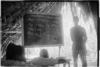 Teacher explaining the decimal system of weights using a blackboard, Guinea-Bissau, 1974